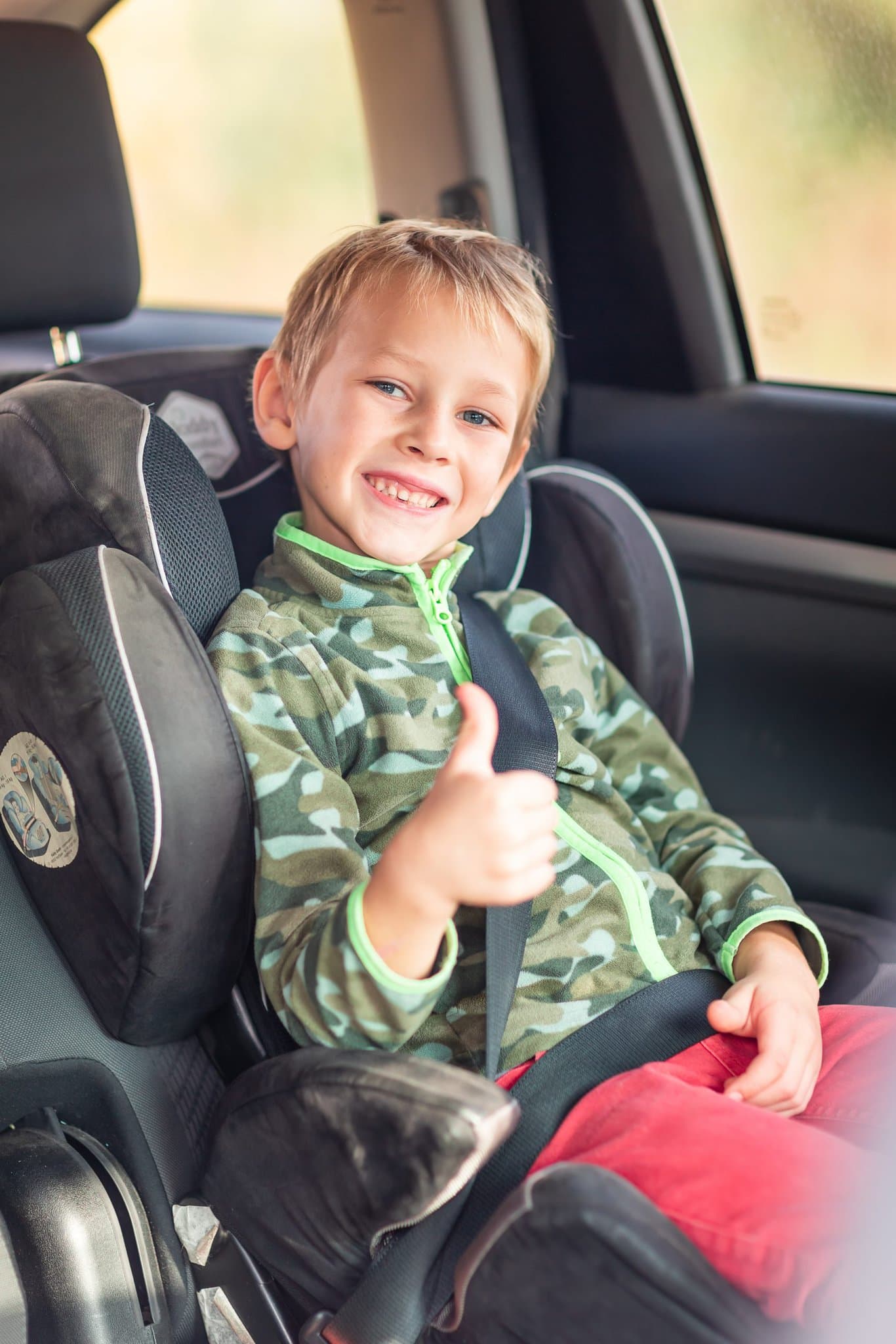 little boy sitting car seat buckled up car children s car seat safety scaled